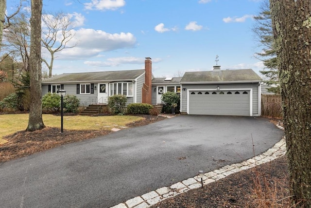 ranch-style house with driveway, a front yard, and a garage