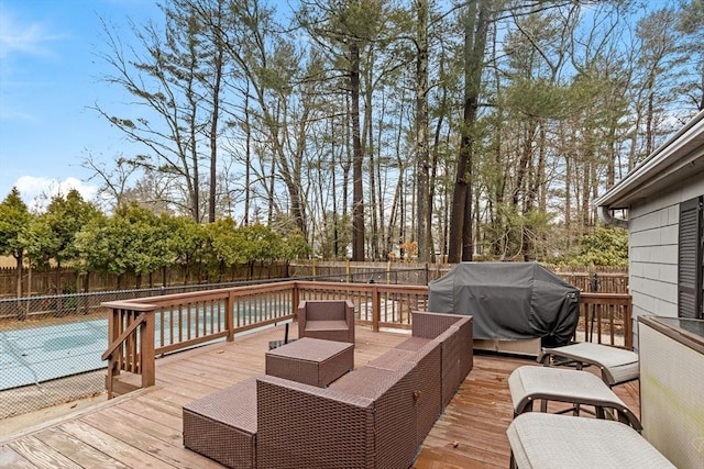 deck with an outdoor living space, area for grilling, and a fenced backyard