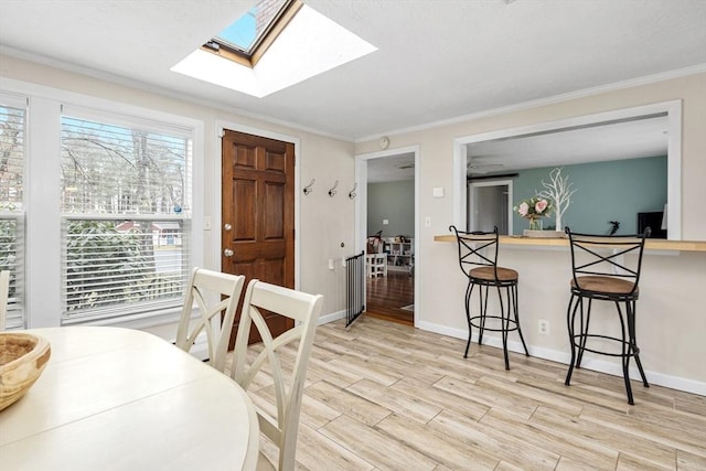 dining space featuring ornamental molding, baseboards, and wood finished floors