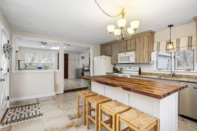 kitchen featuring marble finish floor, a sink, white appliances, butcher block counters, and decorative backsplash