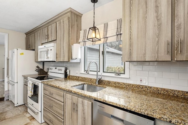 kitchen featuring backsplash, light brown cabinetry, light stone counters, white appliances, and a sink