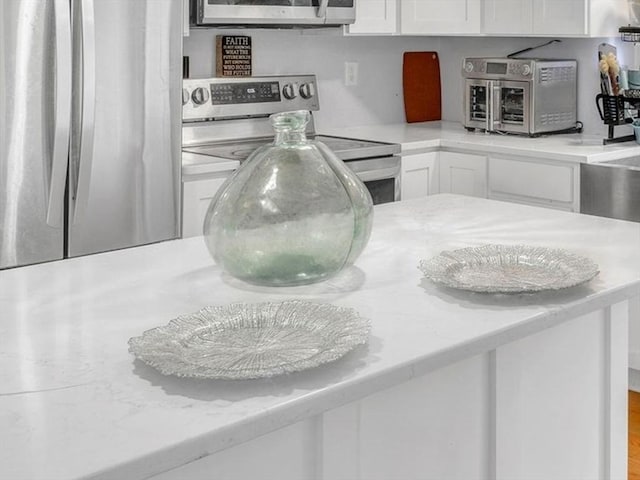 interior details featuring appliances with stainless steel finishes and white cabinets