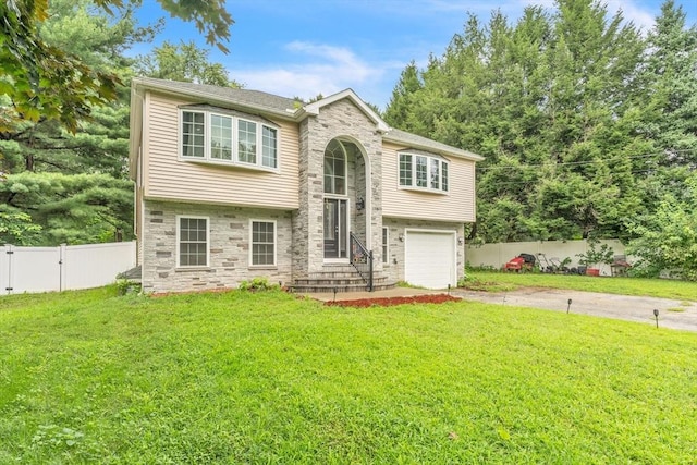 raised ranch featuring a front yard and a garage