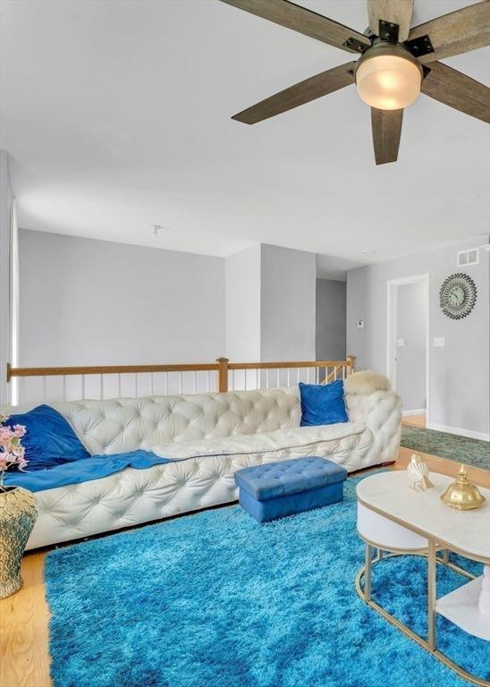 living room with ceiling fan and wood-type flooring