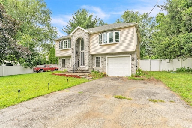 raised ranch featuring a front lawn and a garage