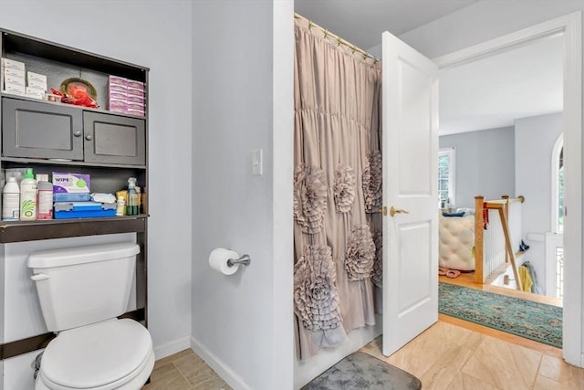 bathroom featuring toilet and a shower with shower curtain