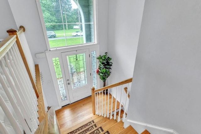 entryway featuring light wood-type flooring and a towering ceiling