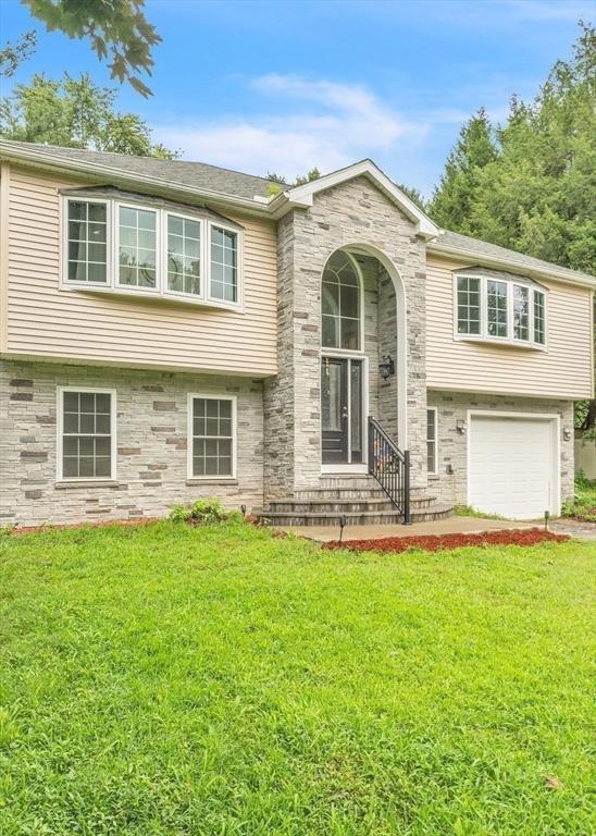 split foyer home with a front lawn and a garage