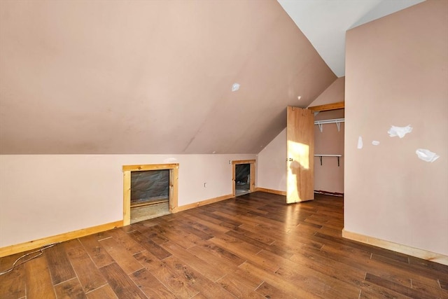 additional living space with vaulted ceiling and dark wood-type flooring