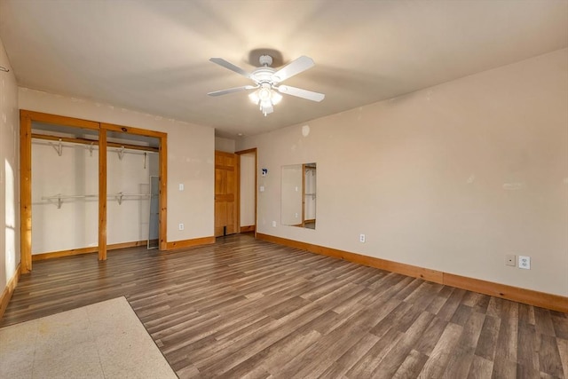 unfurnished bedroom featuring ceiling fan, dark hardwood / wood-style flooring, and a closet