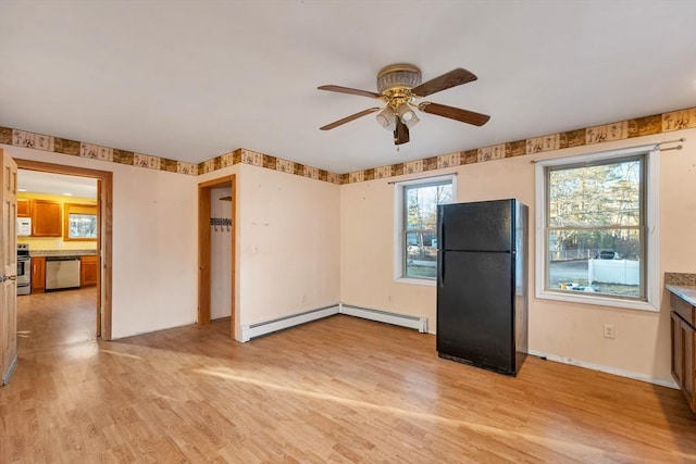 kitchen with appliances with stainless steel finishes, light hardwood / wood-style flooring, ceiling fan, and a baseboard heating unit