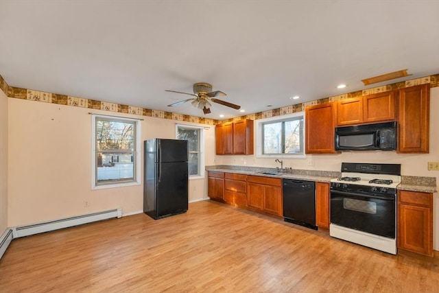 kitchen with sink, light hardwood / wood-style flooring, a wealth of natural light, and black appliances