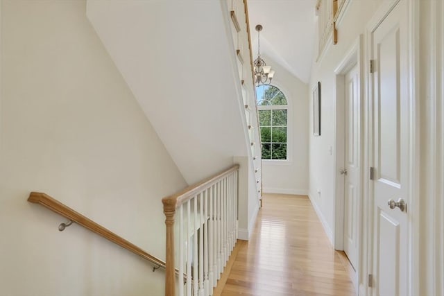 71 Sixth St N, Edgartown, MA 02539 - hall with vaulted ceiling, light wood-style flooring, a chandelier, baseboards, and an upstairs landing