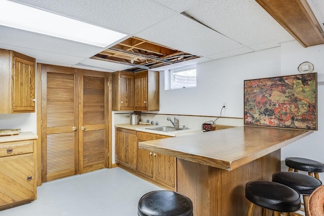 72 Highland Rd, Truro, MA 02666 - kitchen featuring a breakfast bar area, a peninsula, brown cabinetry, finished concrete flooring, and light countertops