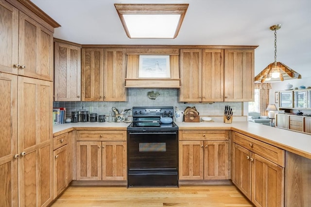 72 Highland Rd, Truro, MA 02666 - kitchen with black range with electric stovetop, decorative backsplash, light countertops, light wood-type flooring, and hanging light fixtures