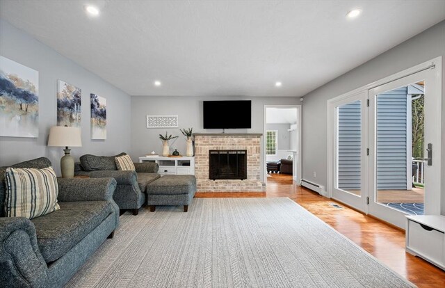 living area featuring a baseboard heating unit, recessed lighting, and wood finished floors