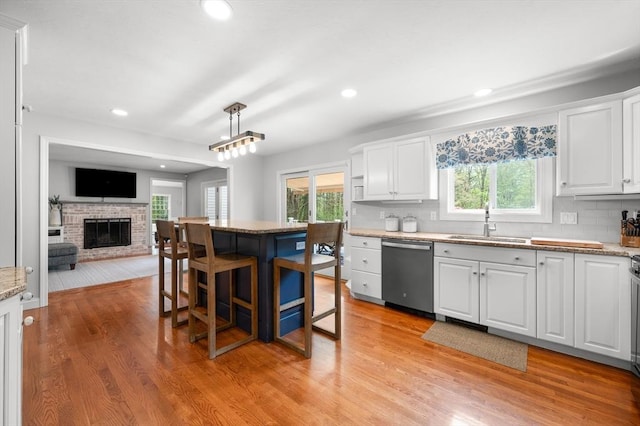 kitchen with white cabinetry, a wealth of natural light, a sink, and dishwasher