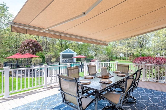 view of patio / terrace featuring a wooden deck, fence, outdoor dining area, and a fenced in pool