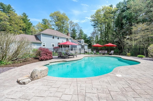 view of swimming pool featuring fence, a fenced in pool, and a patio area