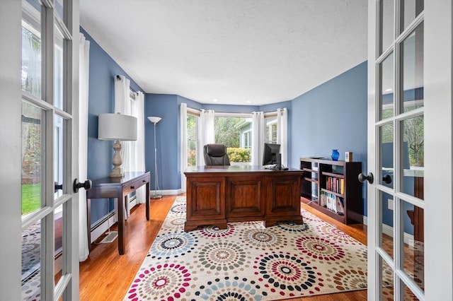 home office featuring light wood-type flooring and french doors