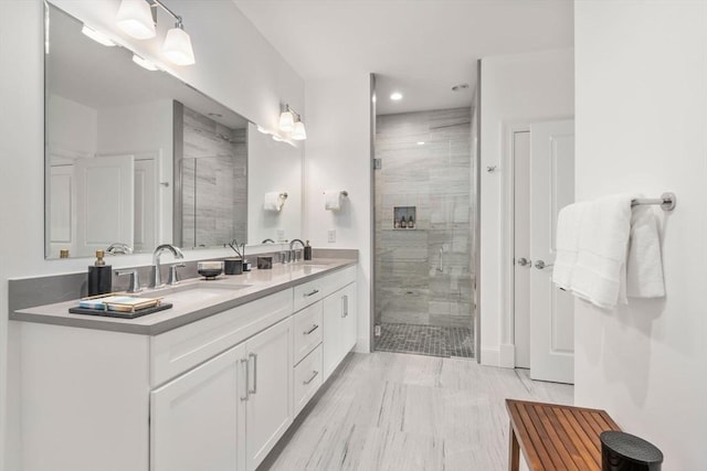 full bathroom with recessed lighting, double vanity, a stall shower, and a sink