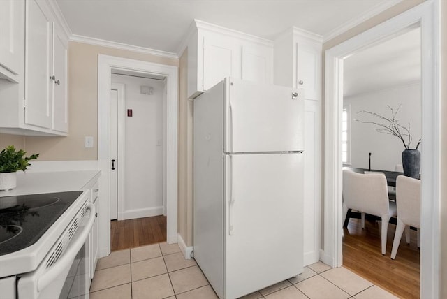 kitchen featuring light tile patterned floors, white appliances, and white cabinetry