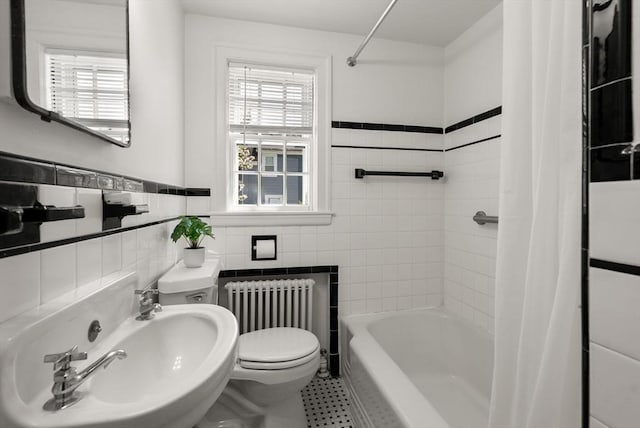 full bathroom featuring tile walls, tile patterned flooring, a sink, toilet, and radiator heating unit