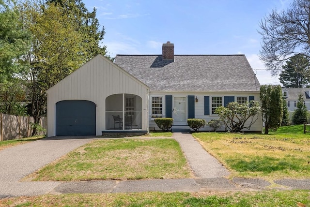 view of front facade featuring a garage, a front lawn, a chimney, a shingled roof, and driveway
