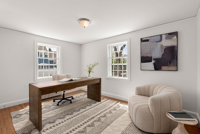 home office featuring baseboards, a wealth of natural light, and wood finished floors