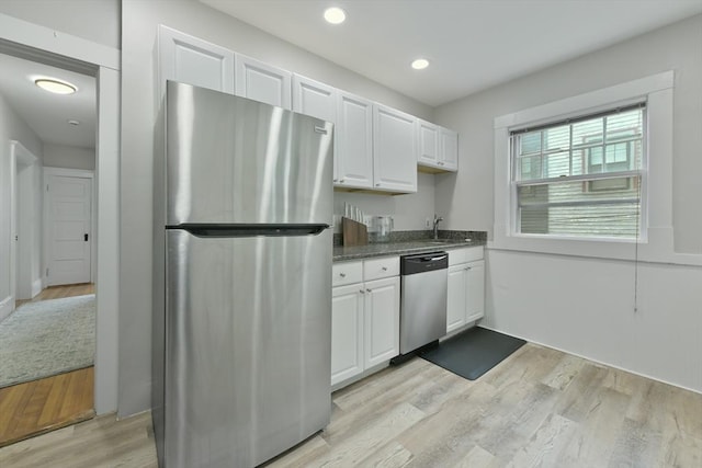 6 Brewer St Unit 2, Cambridge, MA 02138 - kitchen featuring appliances with stainless steel finishes, white cabinets, light wood-style floors, recessed lighting, and dark stone counters