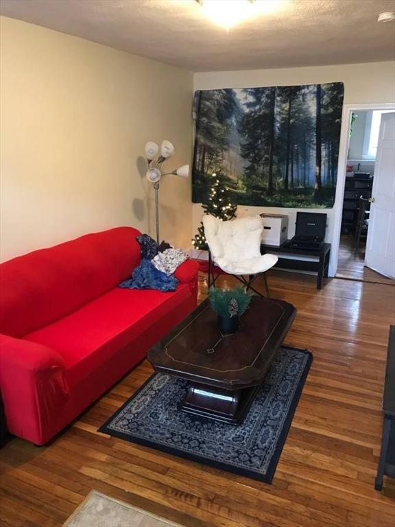 living room with a textured ceiling and wood finished floors