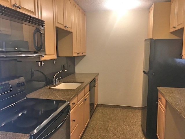 kitchen featuring black appliances, a sink, baseboards, and a textured ceiling