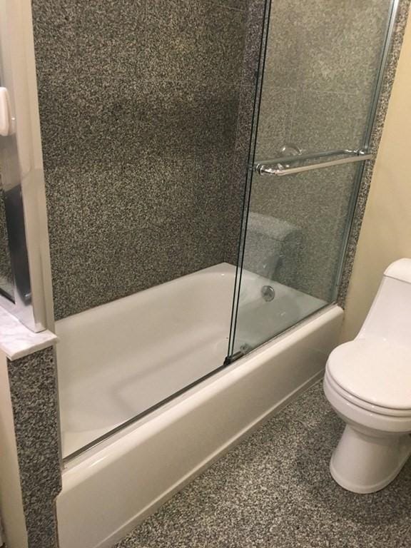 full bathroom featuring shower / bath combination with glass door and toilet