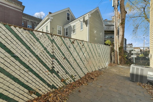 view of side of property with cooling unit and a patio area