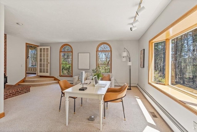 dining area with baseboards, light colored carpet, and baseboard heating