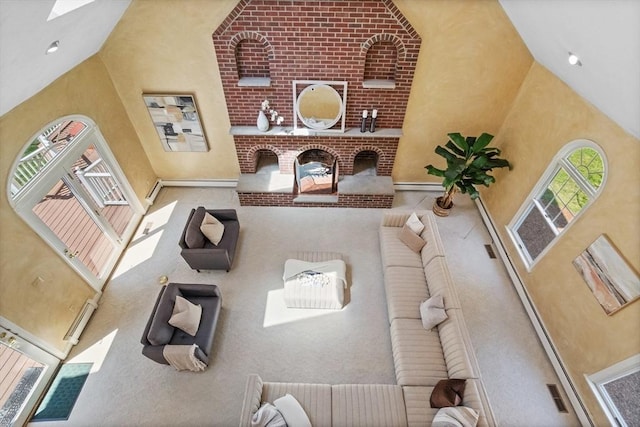 living room with high vaulted ceiling, baseboards, and carpet flooring