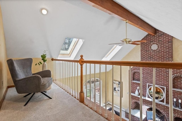 hallway with carpet floors and vaulted ceiling with skylight