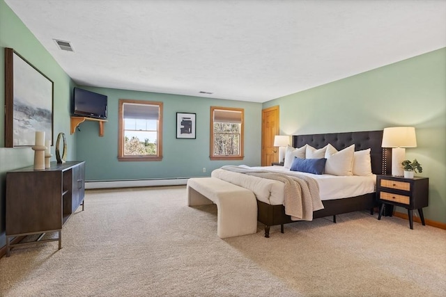 bedroom with light colored carpet, baseboards, visible vents, and a baseboard heating unit