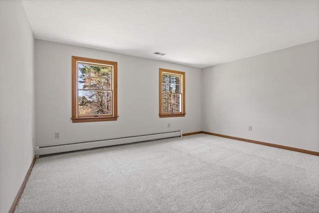carpeted empty room featuring baseboards, baseboard heating, and visible vents