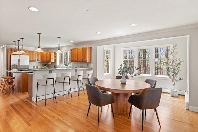 dining space with crown molding, recessed lighting, baseboards, and light wood-style floors