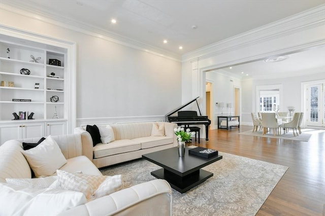 living room with built in features, wood finished floors, recessed lighting, crown molding, and baseboards