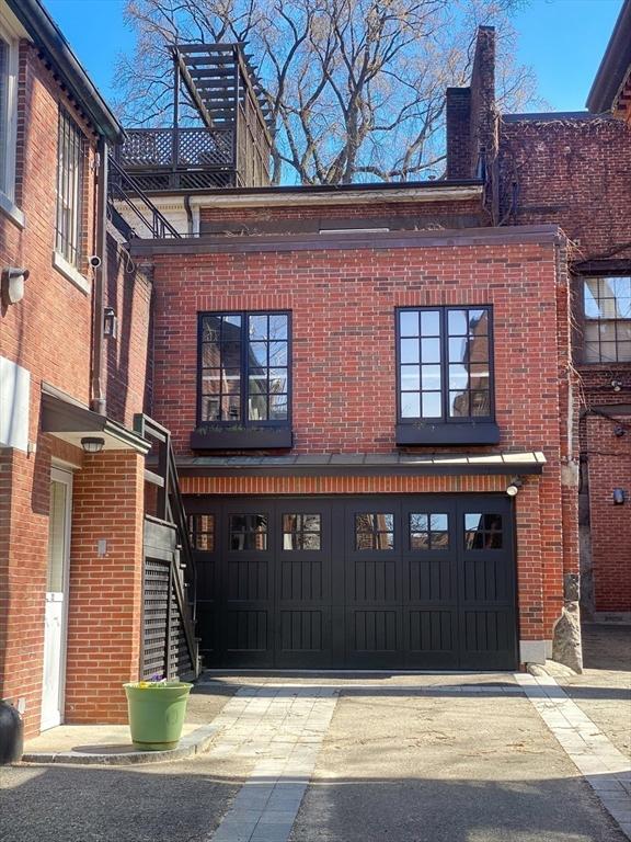 view of front facade with a garage, brick siding, concrete driveway, and stairs