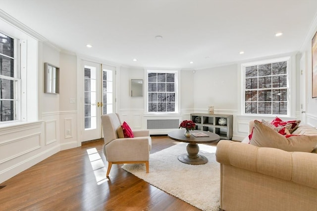 living room featuring recessed lighting, ornamental molding, radiator, and wood finished floors