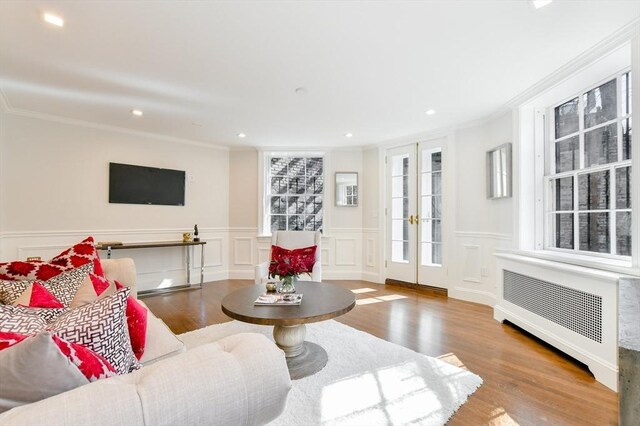 living room with recessed lighting, wood finished floors, crown molding, and radiator heating unit