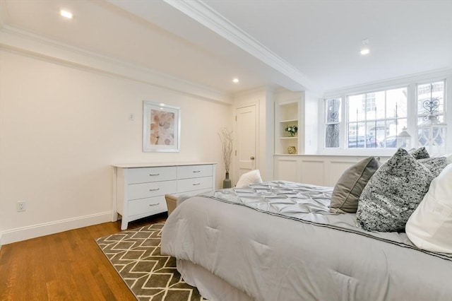 bedroom featuring recessed lighting, baseboards, wood finished floors, and crown molding