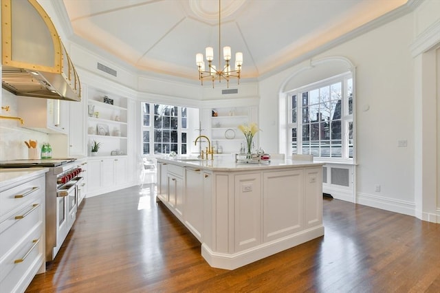 kitchen with a sink, built in features, range with two ovens, an inviting chandelier, and open shelves