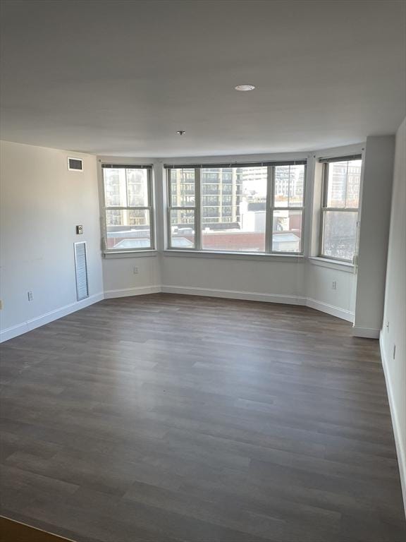 unfurnished room with dark wood-type flooring