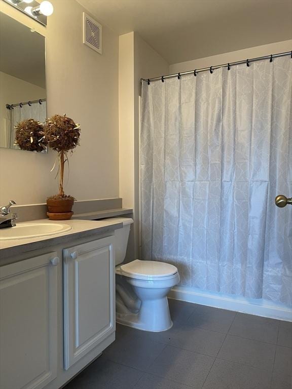 bathroom featuring vanity, tile patterned floors, and toilet