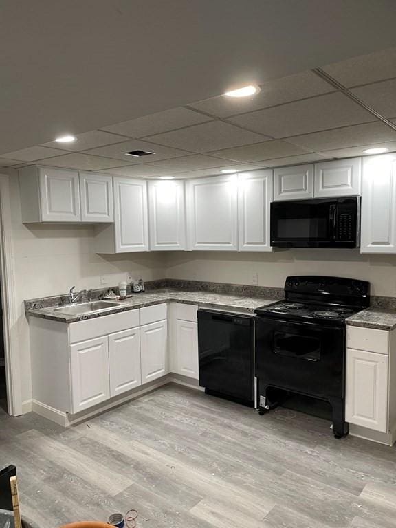 26 Wwebster Rd, Manchester, NH 03104 - kitchen with black appliances, white cabinetry, and light wood-type flooring