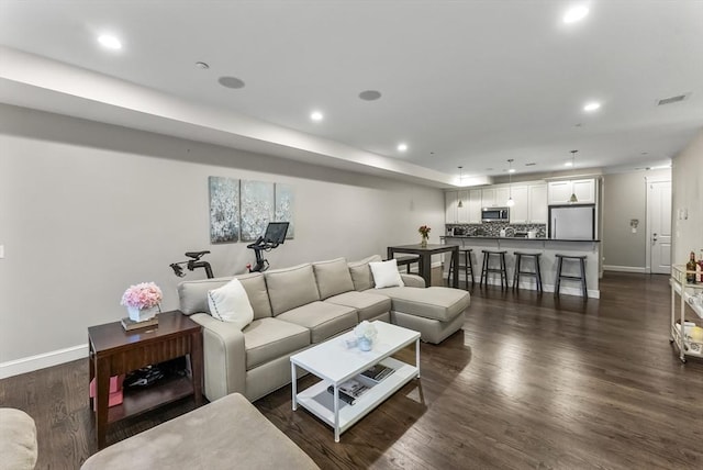 living room featuring recessed lighting, baseboards, and dark wood-style flooring